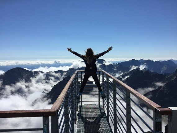 Una mujer en un mirador sobre las nubes.