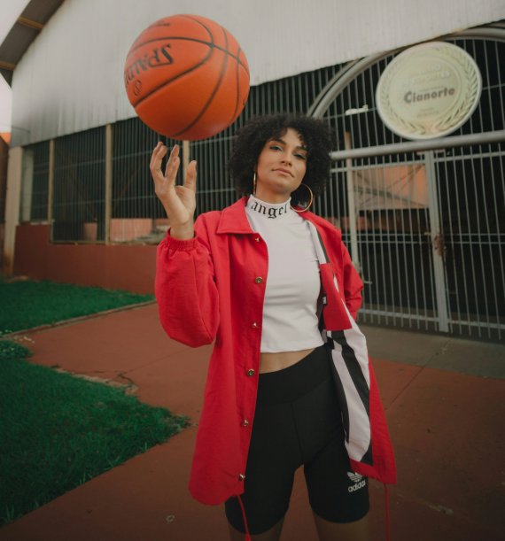 Young woman wearing athleisure clothing spinning a basketball