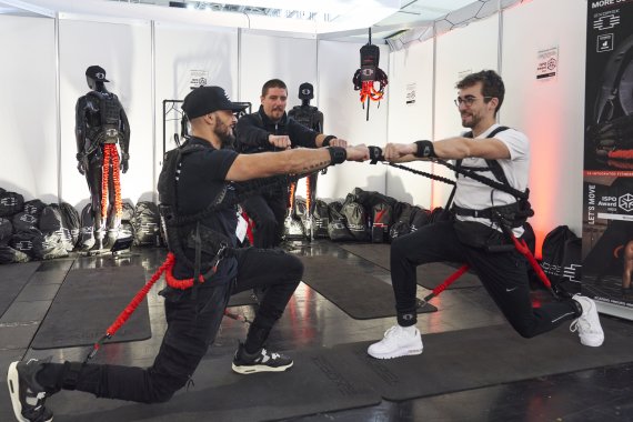 111324_Die Zukunft der Sportmesse_Baender Drei Leute probieren ein Workout mit Bändern?