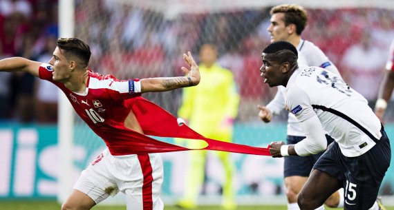 Paul Pogba (right) rips the shirt of Switzerland star Granit Xhaka.