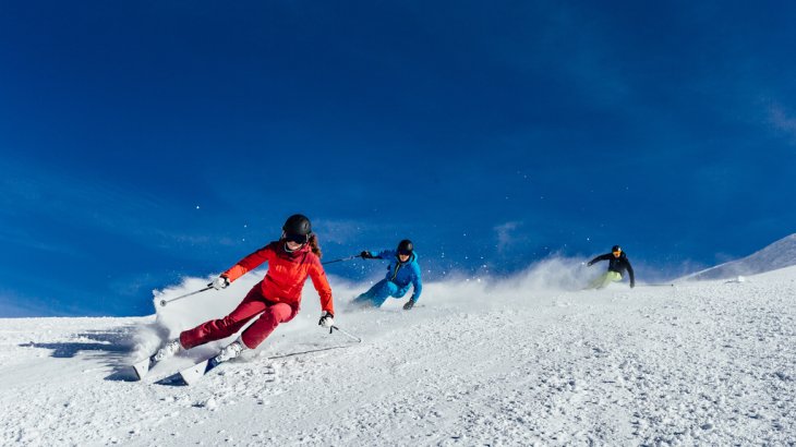 Drei Skifahrer fahren auf der Piste