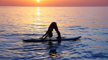 Credit: istockphoto.com/Anna_Om SUP-Yoga promotes concentration and balance, since the exercises are carried out on the water on a surfboard.