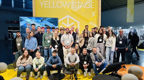 A group picture of the Young Talents in front of the Yellow Stage at ISPO Munich