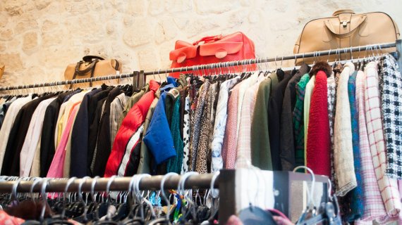 A row of clothes hangs on a clothes rack. 